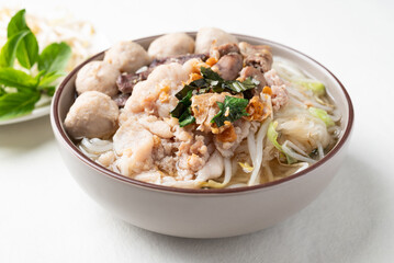 Thai noodles soup with sliced pork, minced pork, meatball and liver in a bowl on white background, Traditional Thai street food