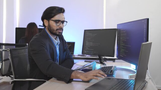 An Indian FinTech engineer engrossed in algorithmic trading platform development at a multi-display rig. Concept for quantitative finance and high-frequency data streams.