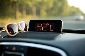 Car Dashboard Showing 42°C Temperature with Sunglasses Resting Beside Display on a Scorching Summer Day
