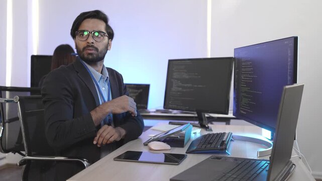 An Indian FinTech engineer engrossed in algorithmic trading platform development at a multi-display rig. Concept for quantitative finance and high-frequency data streams.
