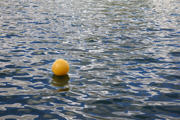 The yellow ball floats on the water surface


