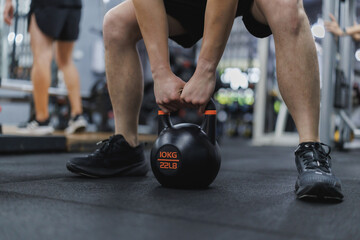 Athlete lifting kettlebell during functional training in gym