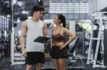 Personal trainer showing results to client at the gym