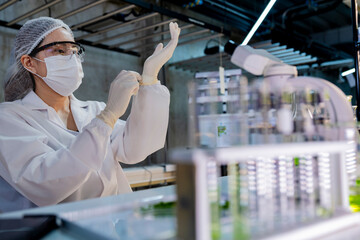 Female scientist in a sterile lab coat and gloves prepares for research in a futuristic...
