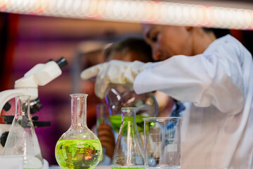 A female scientist teaching a young boy about science in a modern lab. Inspiring the next generation through STEM education, scientific curiosity, and hands on experiments in chemistry and biology.