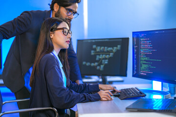 A senior software engineer leads a code review session, mentoring his diverse team on a complex...