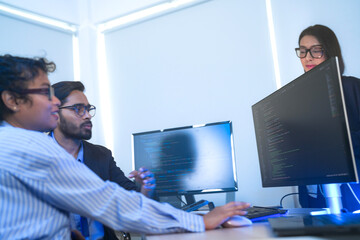 A data science team collaborates, analyzing a neural network model and code on multiple screens. Concept for AI development, machine learning, and data analysis.