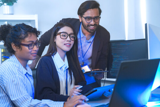 A data science team collaborates, analyzing a neural network model and code on multiple screens. Concept for AI development, machine learning, and data analysis. - Powered by Adobe