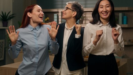 Happy multicultural team women dancing celebrate victory achievement financial deal success business company businesswomen businesspeople win multiethnic females employers coworkers colleagues office