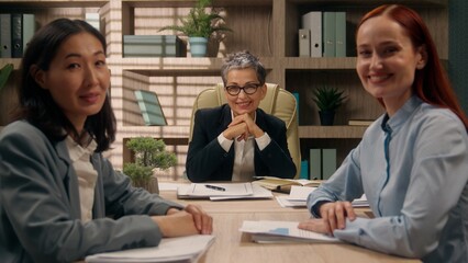 Three multiracial happy females business team businesswomen coworkers office girls group colleagues portrait Caucasian Asian women smiling posing partnership corporate together multiethnic briefing