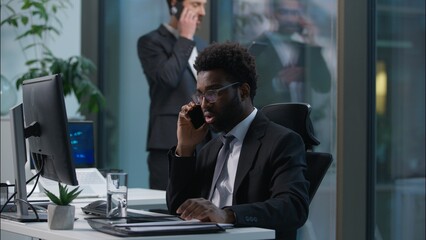 Busy multiethnic coworkers African American Caucasian men talking mobile phone cellphone multitask professional employees businessmen males business office colleagues teamwork consult call cooperate