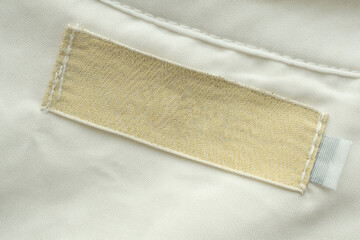 Blank laundry care clothes label on shirt fabric texture background