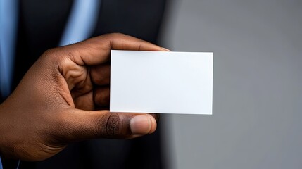 Business Card Presentation: A close-up shot showcases a person's hand holding a blank business card, symbolizing opportunity and professional presentation.