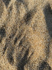 Background of golden beige sand with big rough texture with natural pattern under the sunlight