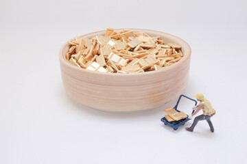 Miniature Worker Pushing a Cart Near Bowl of Gold Bars