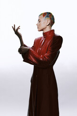 woman with artistic colorful hair wearing red leather coat posing gracefully, stylish fashion,...