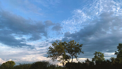 Clouds between innocent white and gloomy floating side by side in the sky on a day when the sky is...