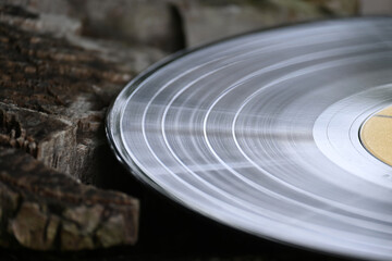 A close-up shot of a vintage vinyl record resting on weathered wood, evoking a nostalgic feel.