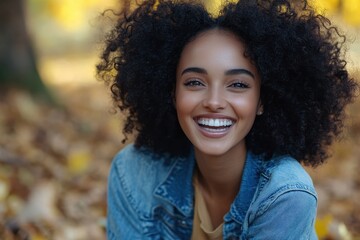 Smiling girl with afro hair poses outdoors in a blue denim jacket. Great for promoting positivity, natural beauty, and fall lifestyle themes.