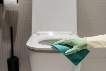 Cleaning a white toilet bowl in a modern bathroom environment