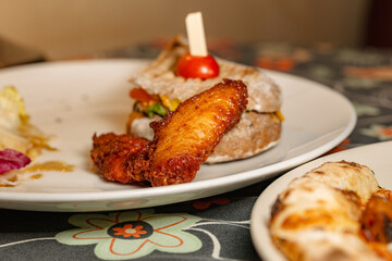 Delicious Fried Chicken Wings and Sandwich with Cherry Tomato Garnish