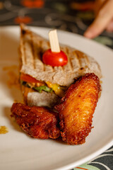 Delicious Sandwich and Crispy Fried Chicken Wings Served on a Plate