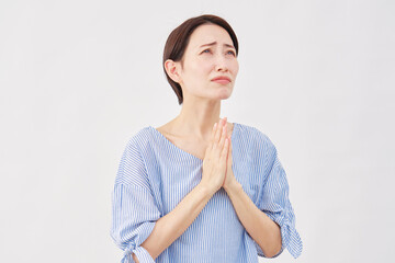 女性　ミドルエイジ　懇願する　合掌　白背景