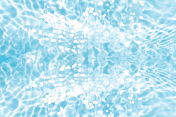 Obraz premium Blue water with ripples on the surface. Defocus blurred transparent blue colored clear calm water surface texture with splashes and bubbles. Water waves with shining pattern texture background.