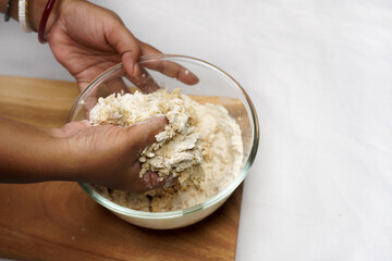 The process of preparing dough. A cook kneads dough from whole grain wheat flour in the kitchen....