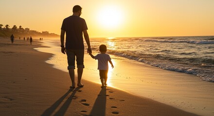 Father and son walking on beach at sunset