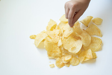 Hand Picking Potato Chips from a Pile