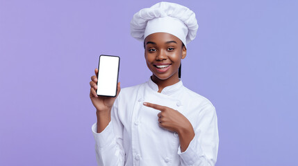 Smiling black female chef pointing at a smartphone with a blank screen. Ideal for app mockups, cooking apps, or modern culinary promotions with a friendly professional touch.