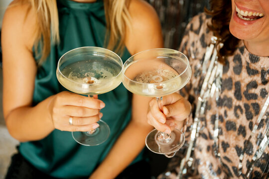 Two women celebrating, holding champagne glasses at a party