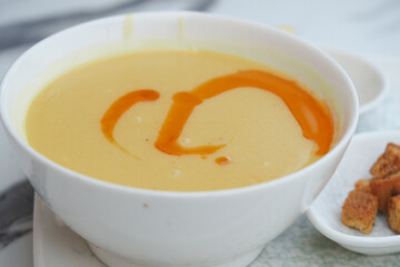 Warm bowl of creamy soup with drizzle and croutons