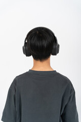 ヘッドフォンで音楽を聴く少年の後ろ姿