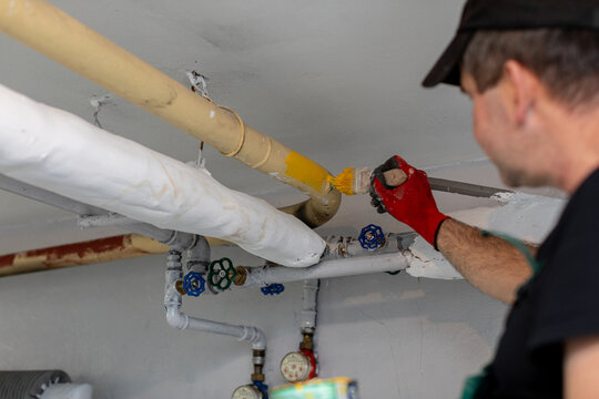 A skilled plumber is currently working diligently on various pipes within a residential setting