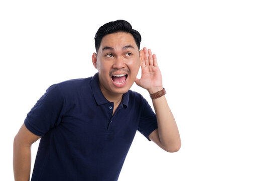 Curious young Asian man listening attentively with hand cupped to ear isolated on transparent background