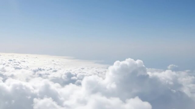 Clouds fill the lower frame transitioning to a clear blue sky above