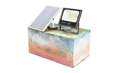 Spotlight with solar panel on concrete pedestal isolated on cut out PNG or transparent background. . Solar panel small with light bulb. Saving electricity by sunlight energy as renewable energy clean.