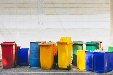 Lot of colorful trash cans on street. Wheelie bins in row segregated for recycling rubbish....
