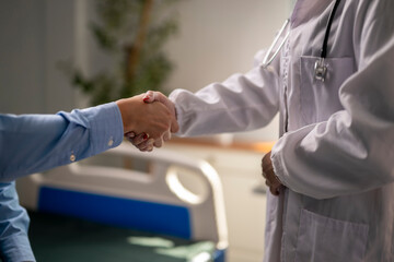 Obraz premium doctor shakes a patient's hand in a hospital room