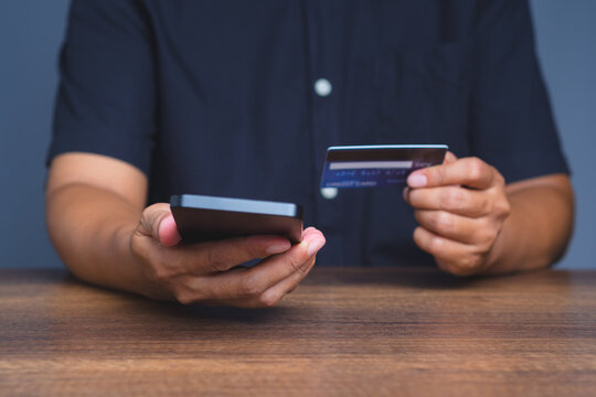Close-up of hands using a smartphone and a credit card, representing digital transaction and e-commerce.