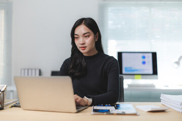 Young asian businesswoman working with laptop in modern office