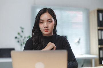 Young asian businesswoman working with laptop in office is having a video call