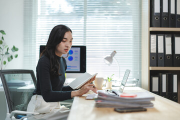 Businesswoman working with calculator and documents at office desk