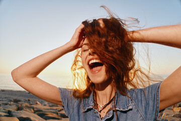 Lifestyle woman with modern boho-western denim street style laughing joyfully outdoors at sunset...