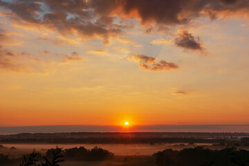 Colorful sunrise over misty forest landscape