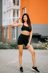 Obraz premium Confident woman posing in activewear at an urban outdoor fitness area during daytime