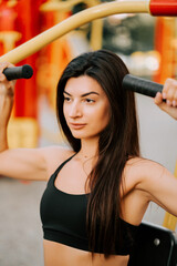 Woman exercising in an outdoor gym in a vibrant urban park during the late afternoon