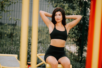 Young woman exercising in outdoor gym during sunny day